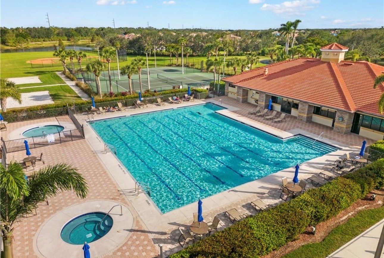 The image showcases modern single-family homes in Gateway's Cypress Cay subdivision, featuring a variety of architectural styles and well-maintained landscaping. This vibrant community is part of Gateway real estate, known for its popular amenities including a golf course, fitness center, and a picnic area, making it a desirable location in Fort Myers, Southwest Florida.
