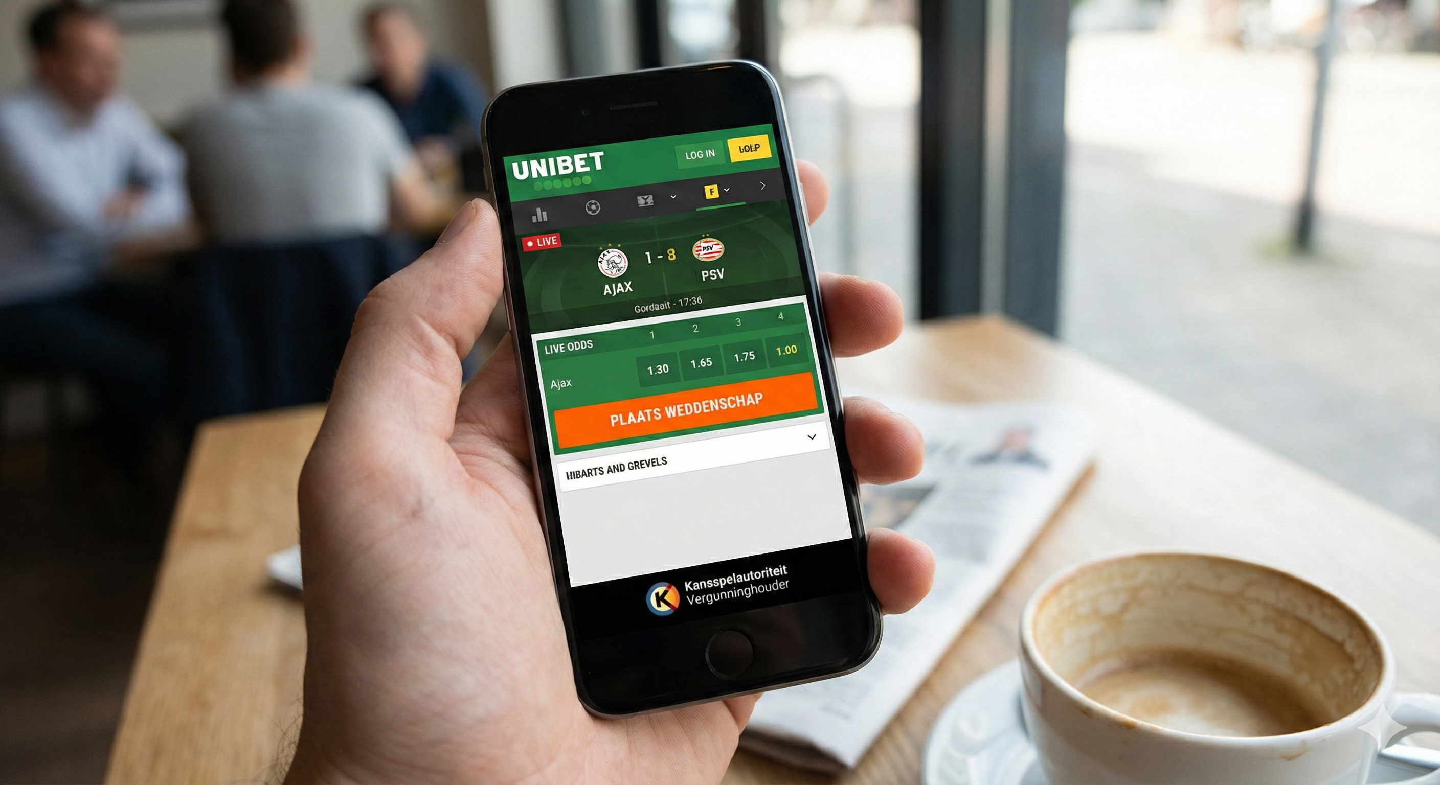 Man plaatst live wedden op Unibet via smartphone in café.