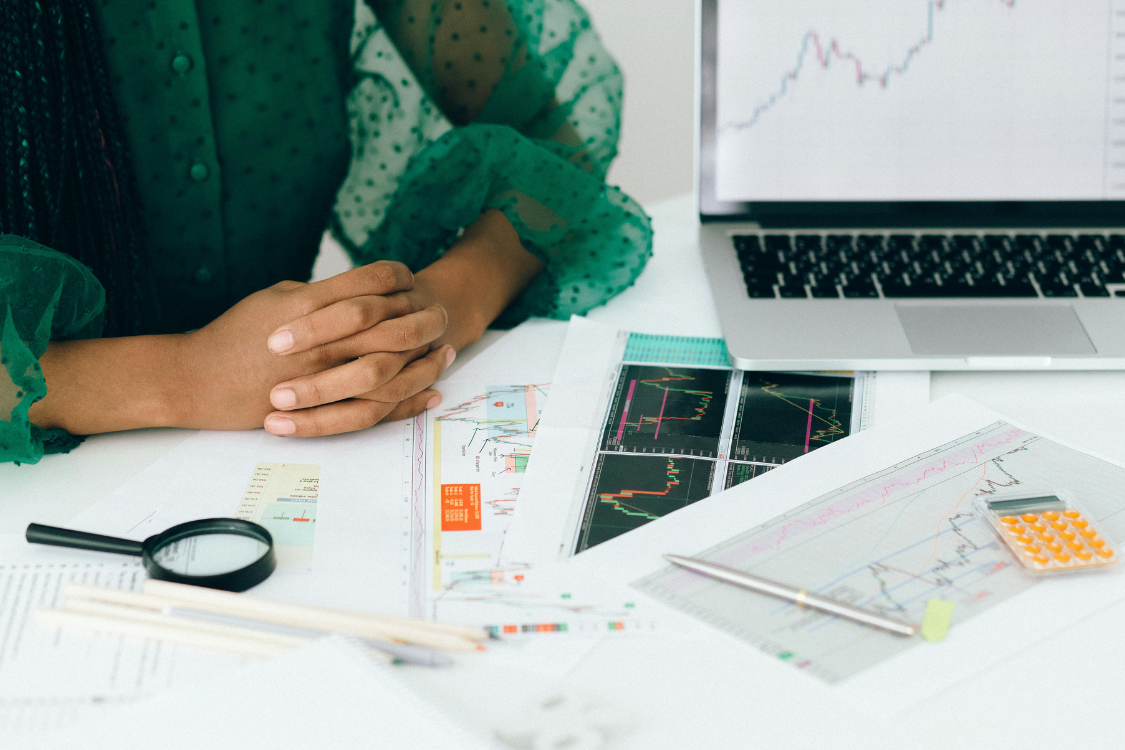 A professional sitting at a desk with job data charts and a laptop, representing remote hiring and recruitment analytics.