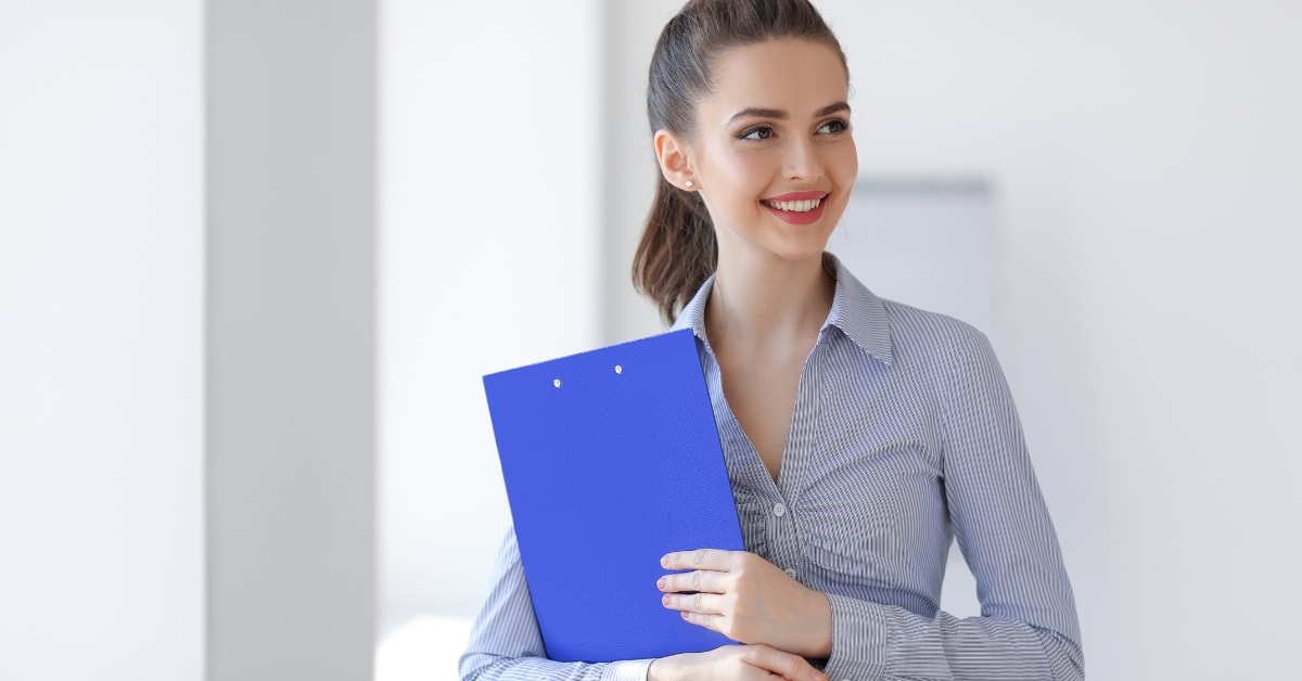 A smiling professional holding a blue folder, showcasing the benefits of OnlyFans tax compliance services.