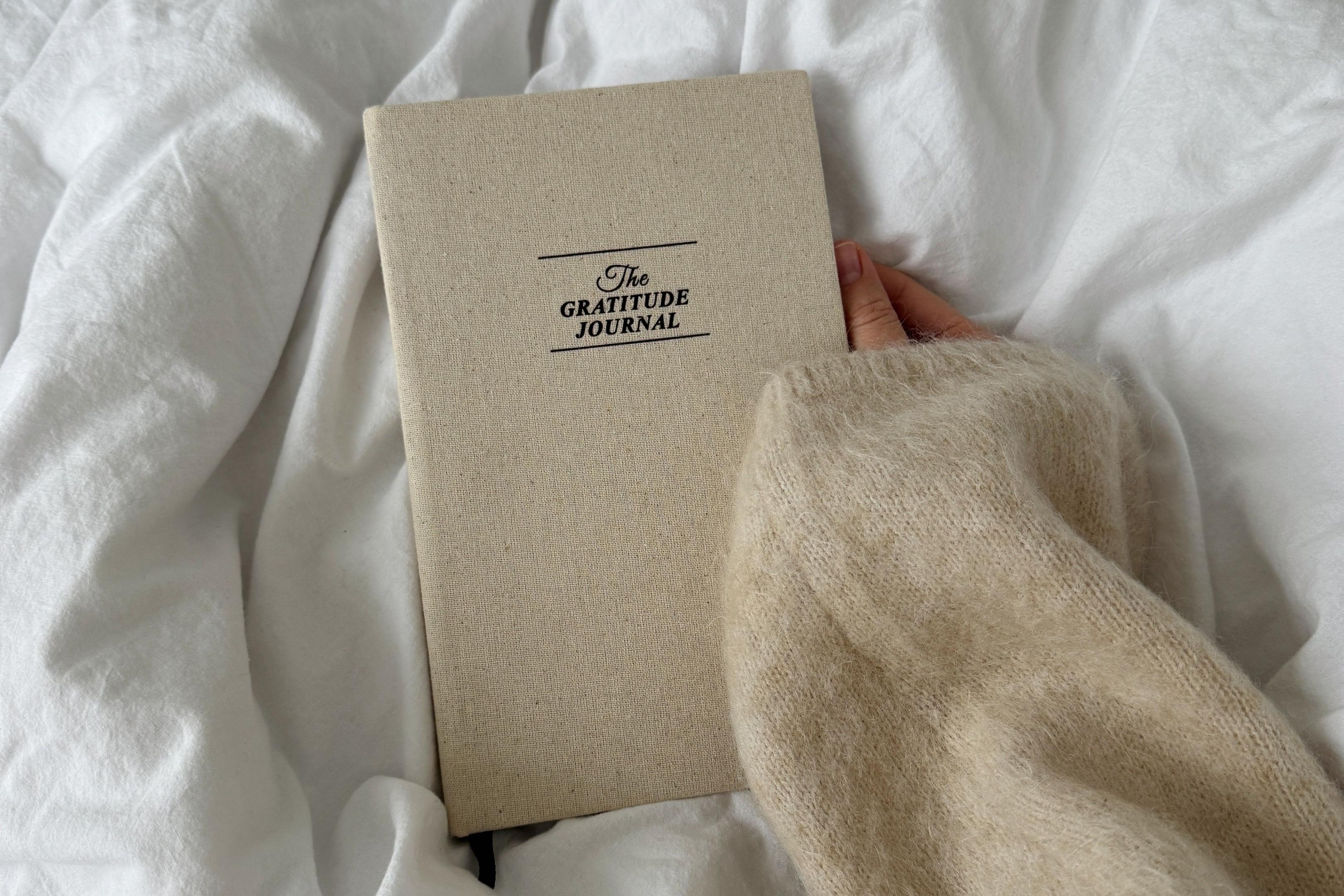 A woman holds her gratitude journal.