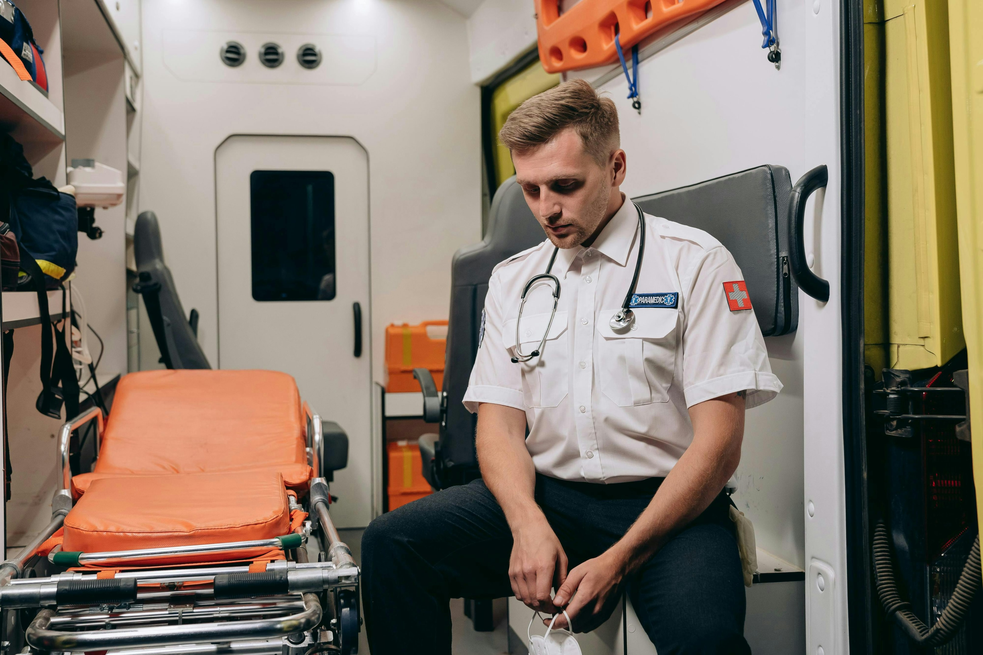 An EMT professional in an ambulance with a stretcher. 