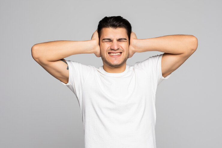 Man covering his ears to block loud noise