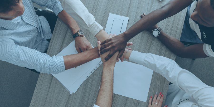 Men and women holding hands as a team