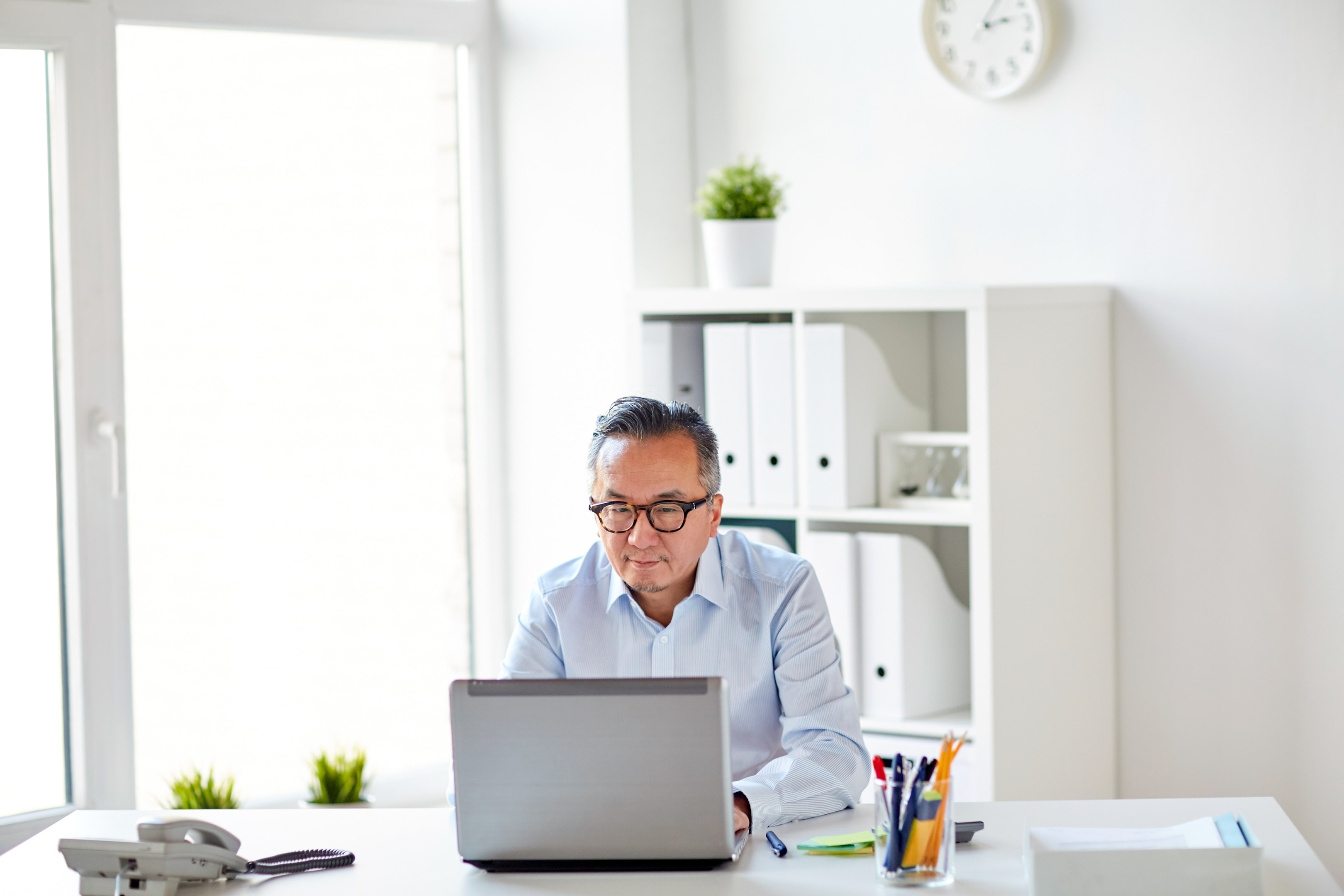 Office worker at his desk using a laptop.