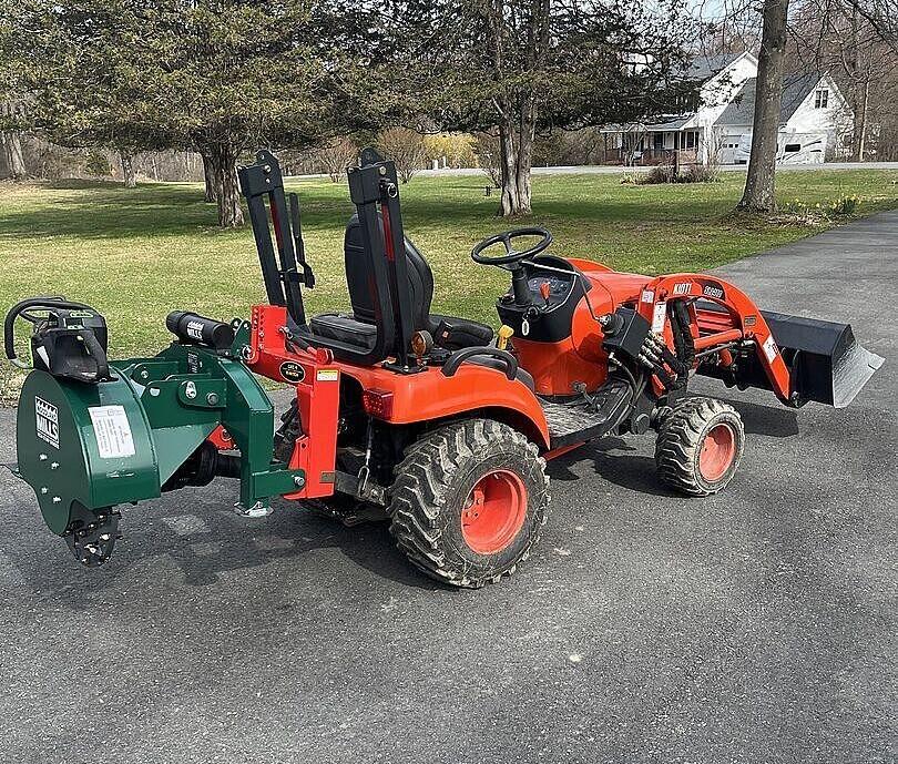 A Woodland Mills WG24 Stump Grinder attached to the back of a tractor.