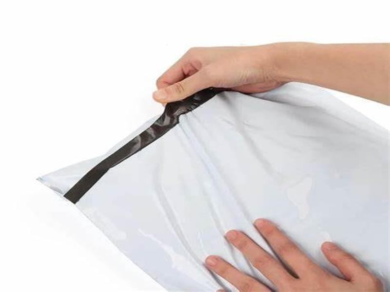 A person stretching a mailing bag to show how durable it is, demonstrating the strength and resilience of the shipping bag.