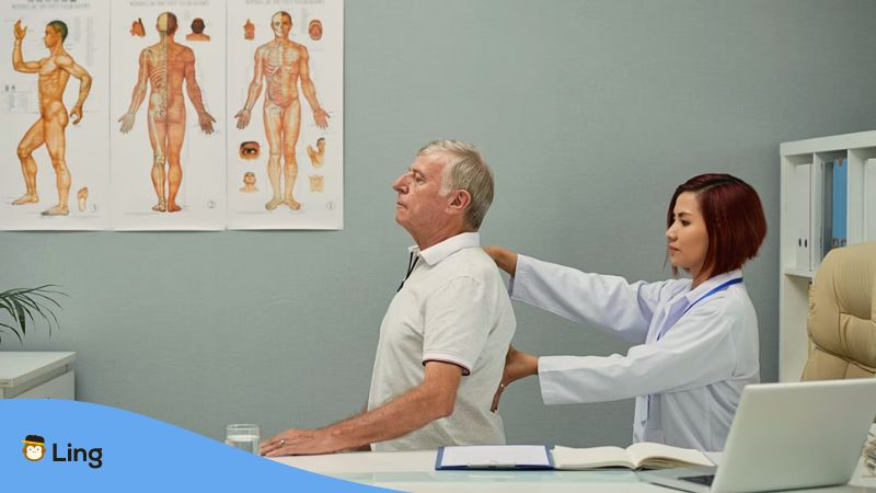 A photo of a female doctor checking up on her elderly male patient inside a clinic.