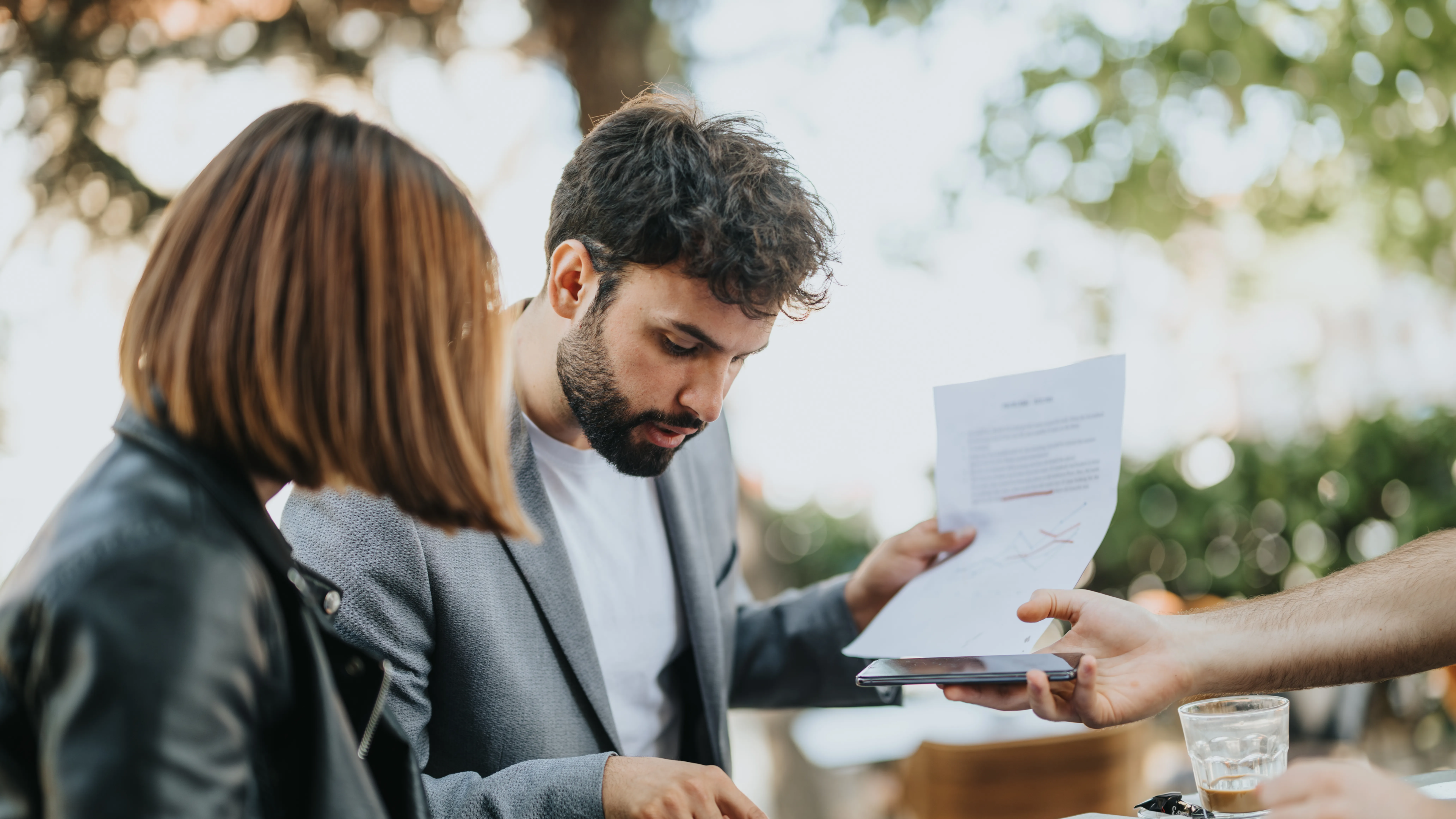 Small business owners reviewing website design costs and budgeting documents, discussing short-term expenses and long-term growth factors for their small business' web development projects.