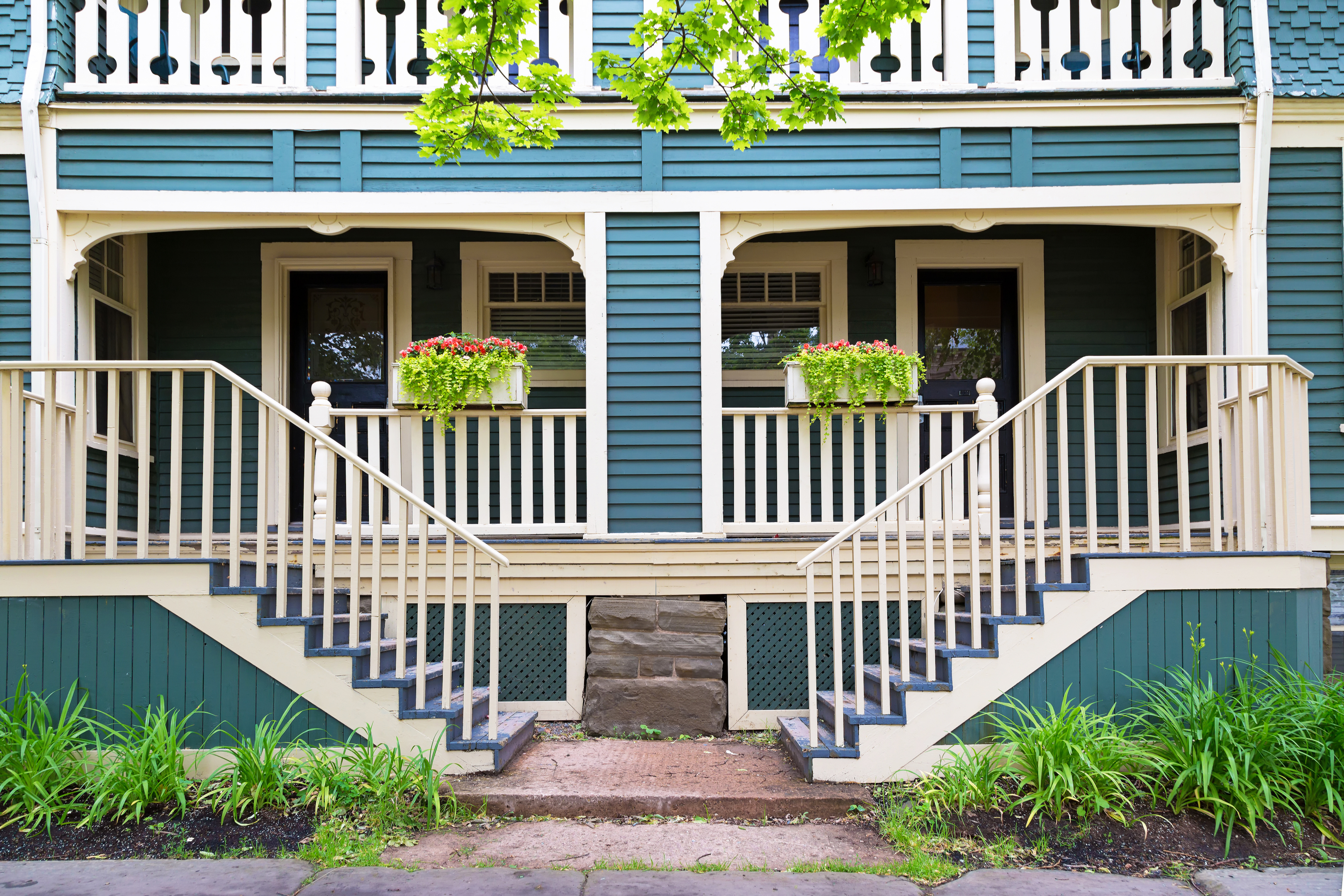 Light blue home exterior with matching planters on the front porch.