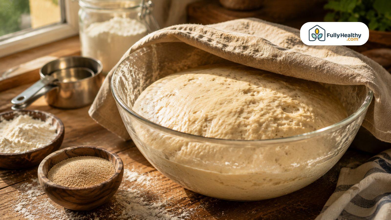 Fresh bread dough rising beside yeast and flour in rustic kitchen setting