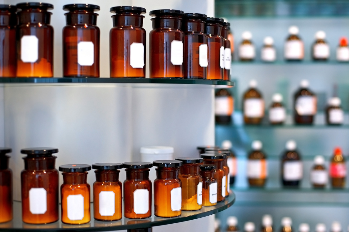 Amber glass bottles with blank labels displayed on shelves in a supplement manufacturer’s lab for product sampling