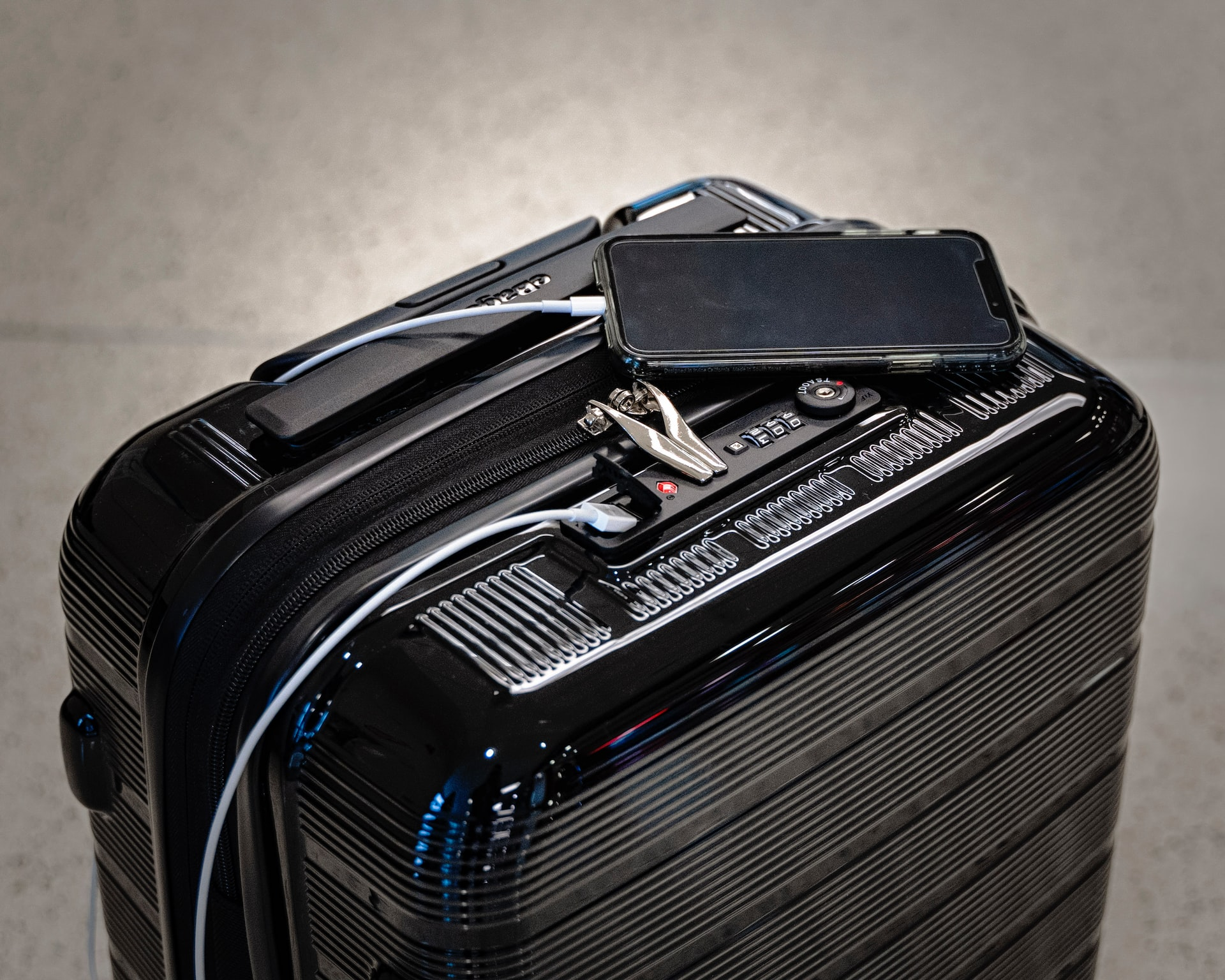 A phone charging from a power bank in a suitcase.