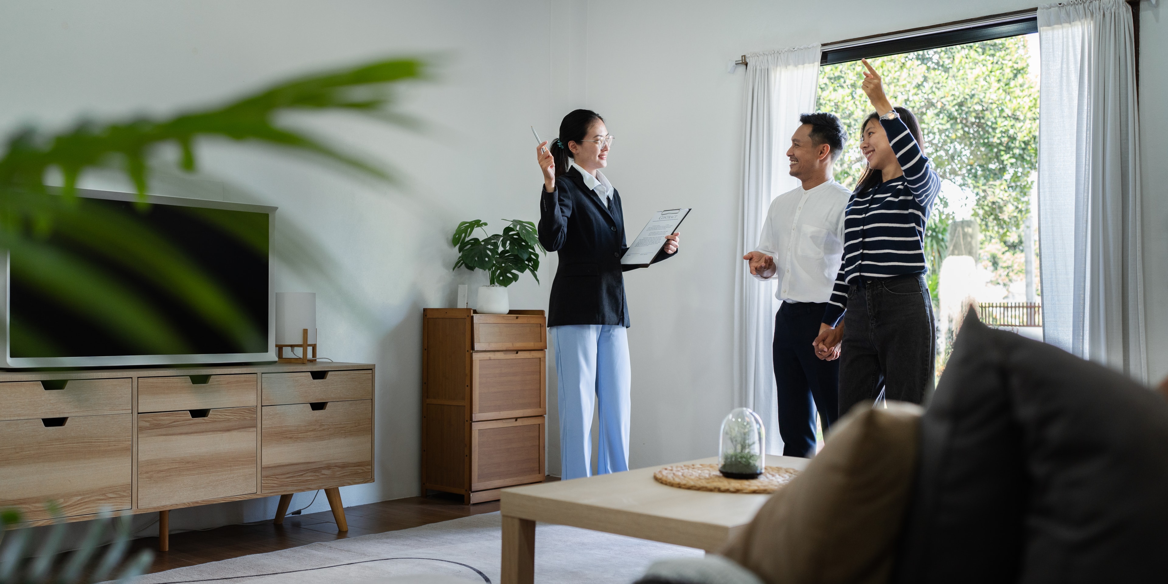young couple with a real estate agent visiting home for buy or for rent
