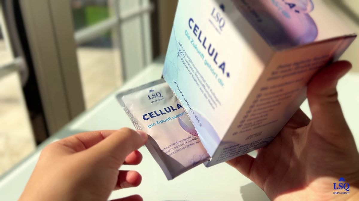 Person hält ein Sachet von Cellula+ vor geöffneter Produktverpackung mit Aufdruck „30 Portionsbeutel – 204 g“. Die Marke LSQ ist klar zu erkennen.