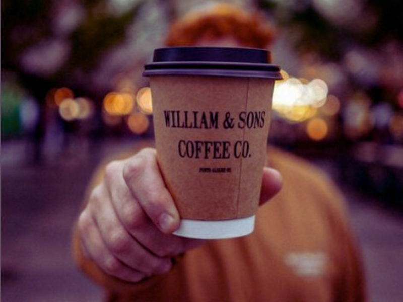 Homem segura copo de papel da William Sons Coffee CO. Imagem: Reprodução Instagram. 