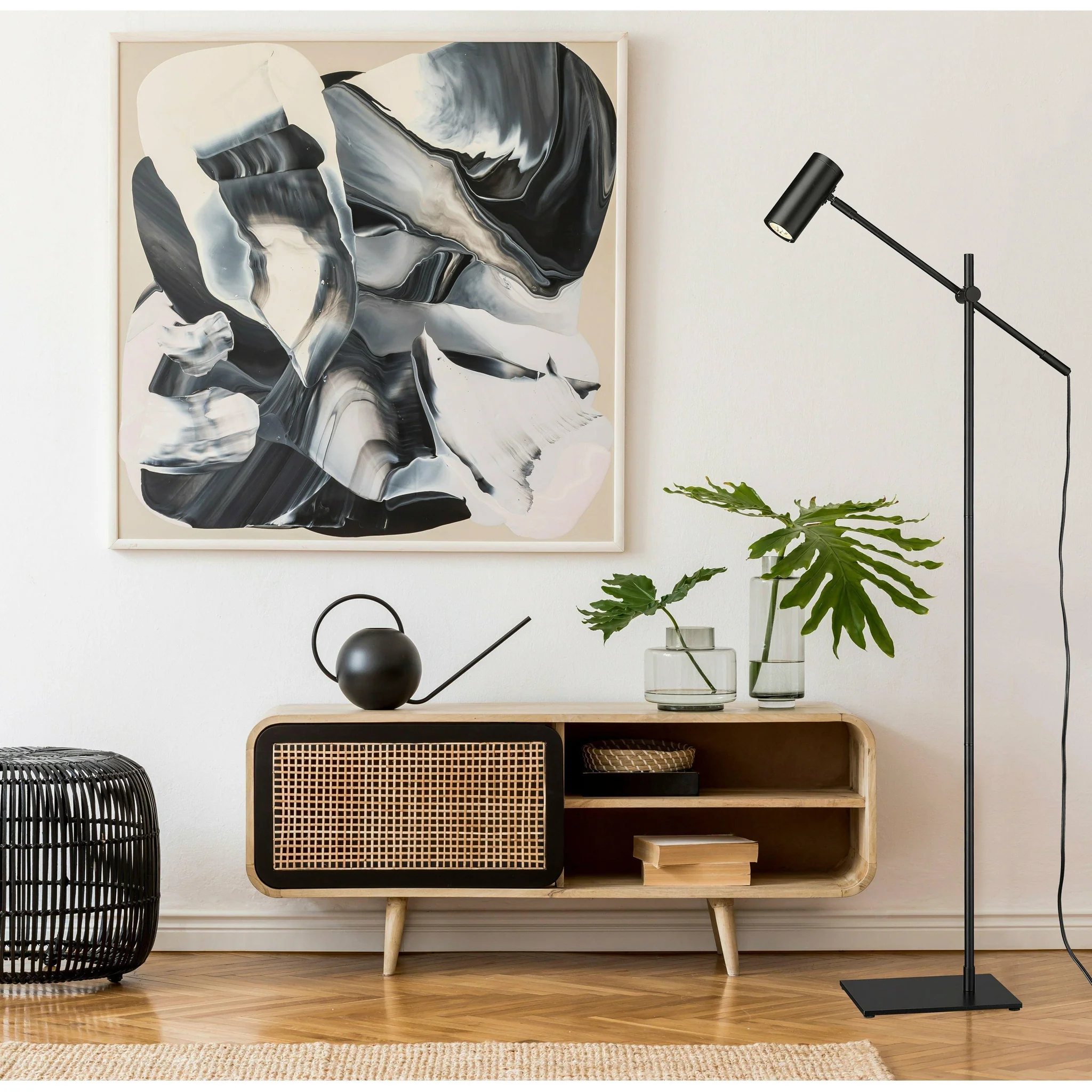 Scandinavian-style living room with a cane wood console table, black floor lamp, and abstract wall art.