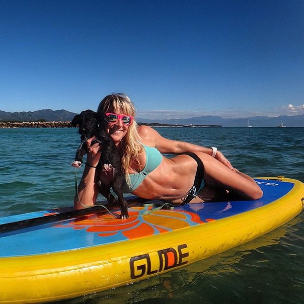 woman with her dog on an inflatable sup board