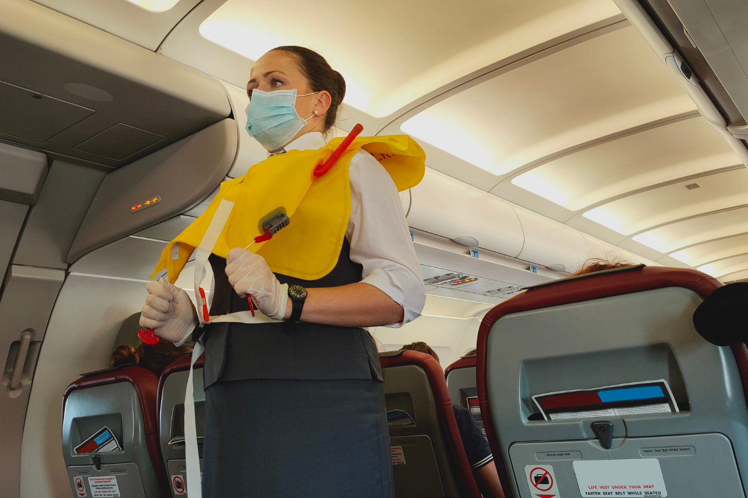 an airhostess demonstrating safety measures to the passengers