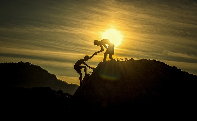 Two people climbing a cliff 