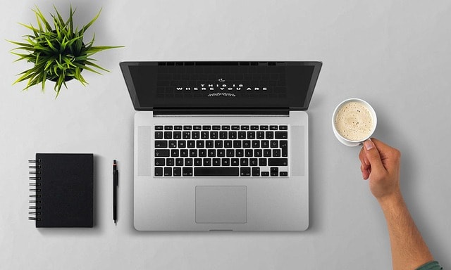 A notebook and laptop representing online creative writing courses.