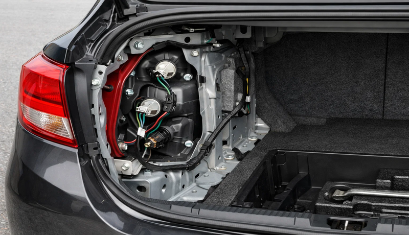 Accessing tail light housing by removing rear trim panel 