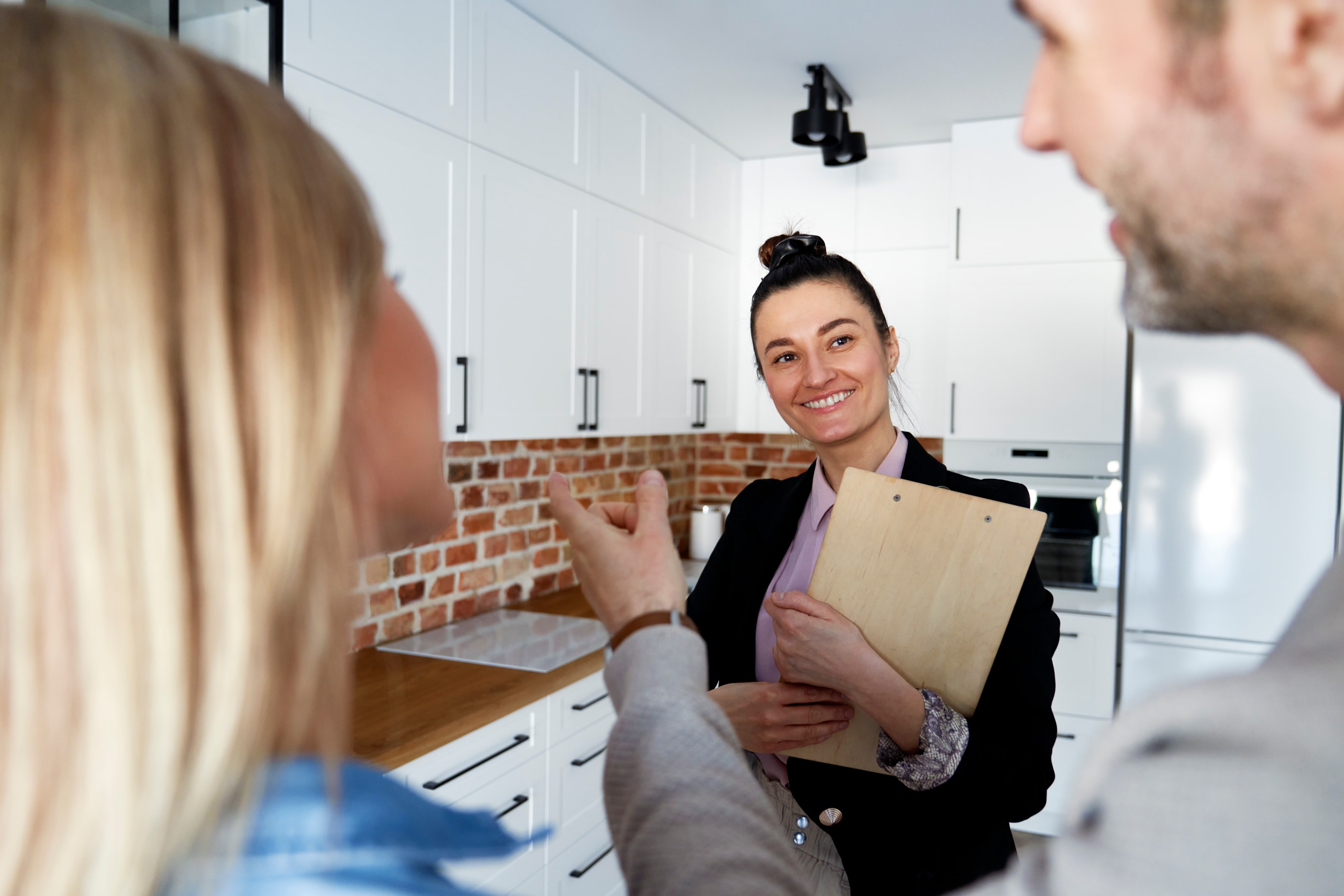 real estate agent talking to couple about how to find a property for free