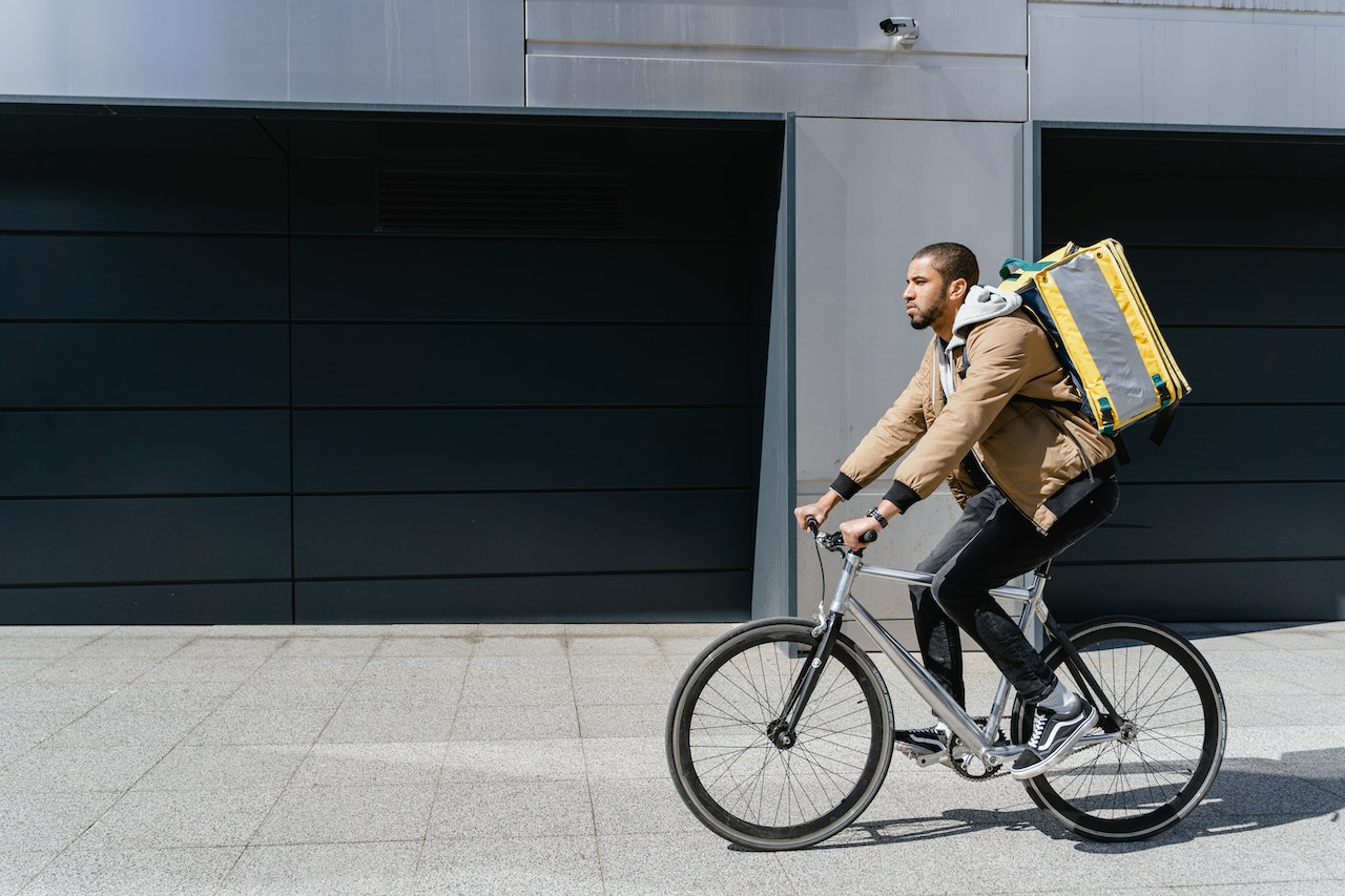 Entregador e bike andando de bicicleta. Foto: Pexels