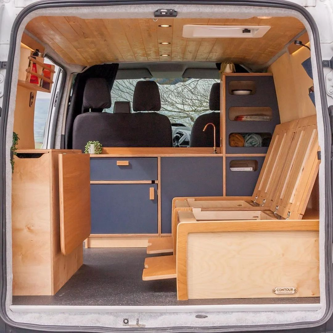 Same van conversion as previous photo, displaying beneath the bed now being used as a storage and organizational space. 
