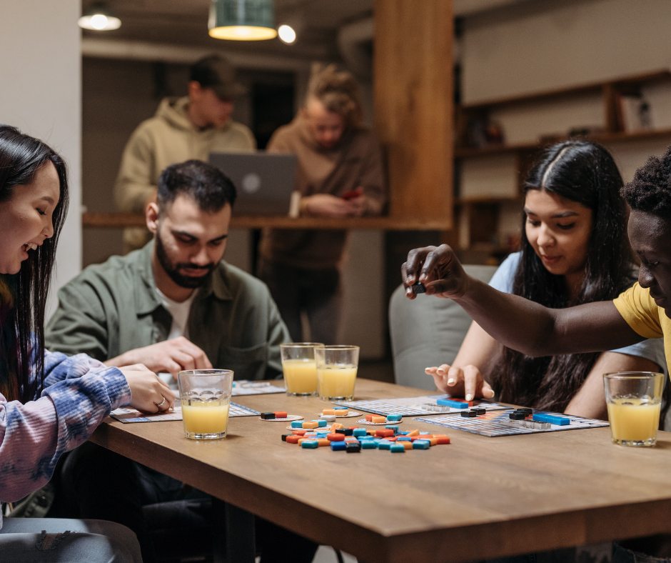 Group of friends playing board games and drinking alcohol