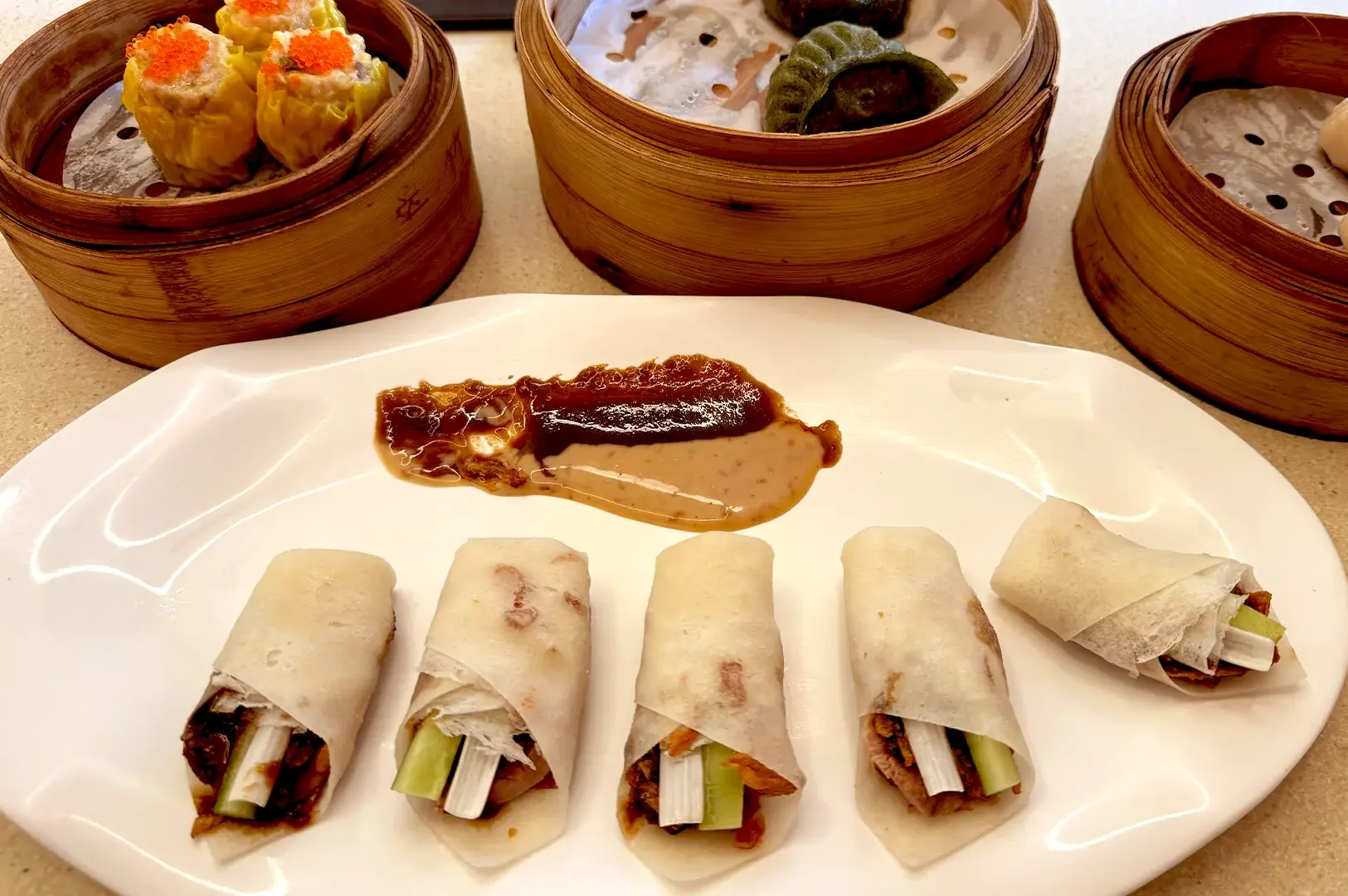 Signature duck rolls served alongside traditional dim sum baskets, highlighting the unique halal-certified Chinese dining experience at The Dim Sum Place.