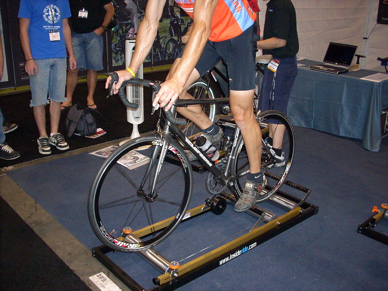 Ciclista experimentando pedalar com rolo de treino para bike