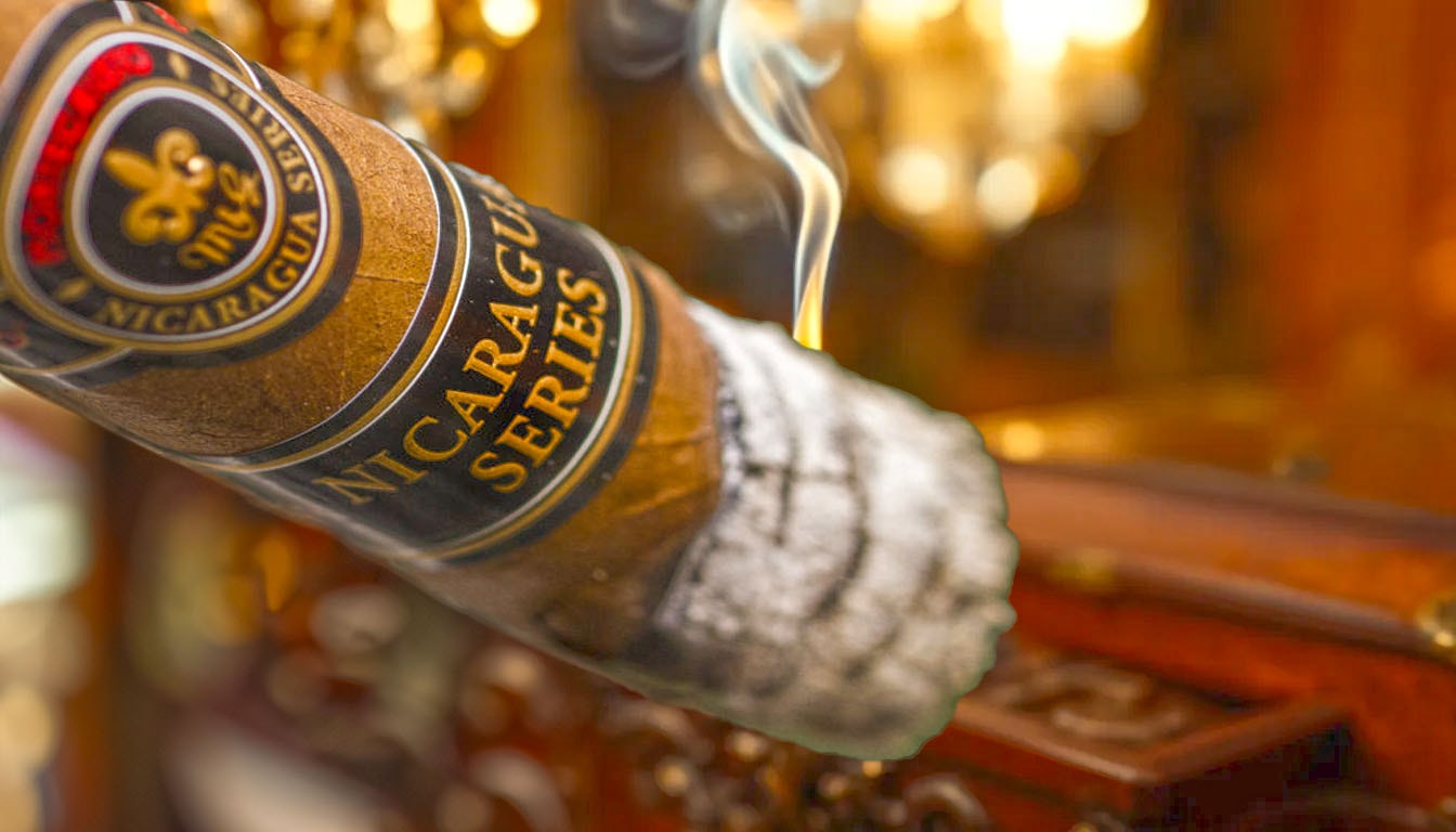 A close-up of a cigar being lit, releasing aromatic smoke.