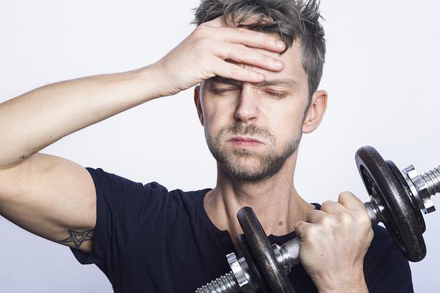 Stressed man working out with a dumbbell