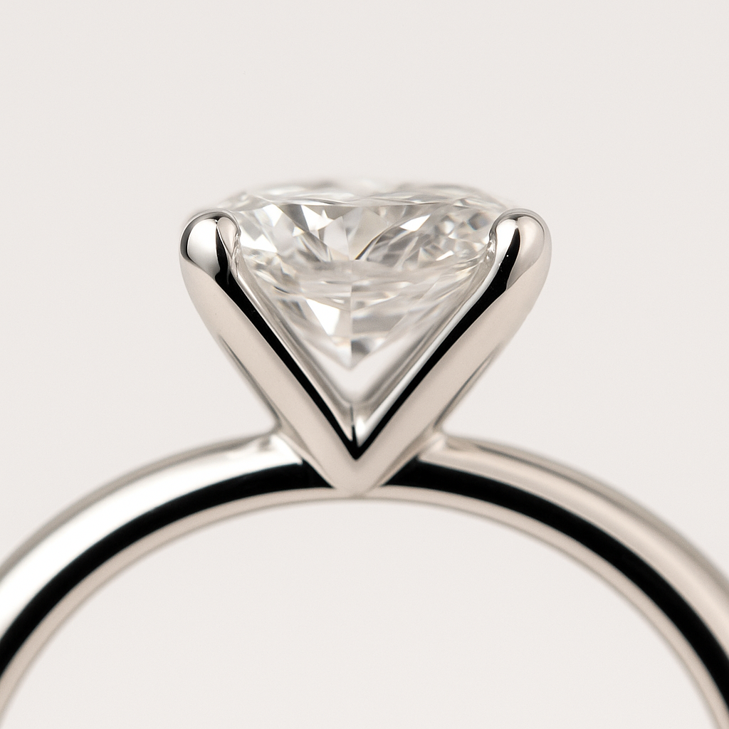 Rankomis kurtas sužadėtuvių žiedas iš balto aukso su apvaliu briliantu centre – unikalus juvelyro meistrystės kūrinys.