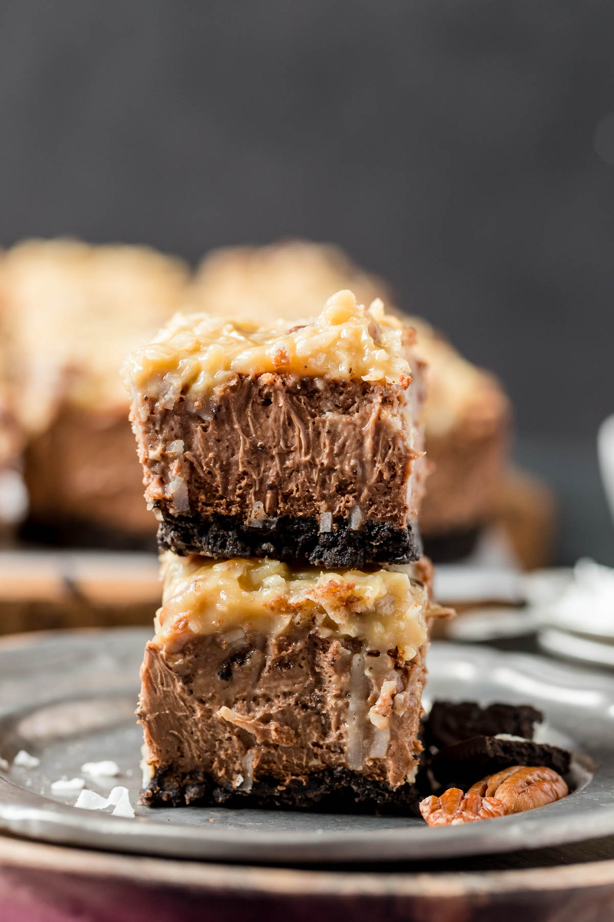 two german chocolate cheesecake bars stacked on top of each other