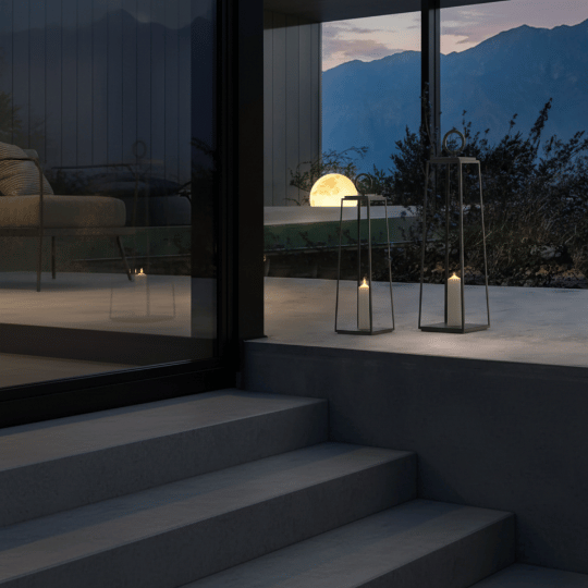 Outdoor cottage steps illuminated by decorative lantern lights at dusk.