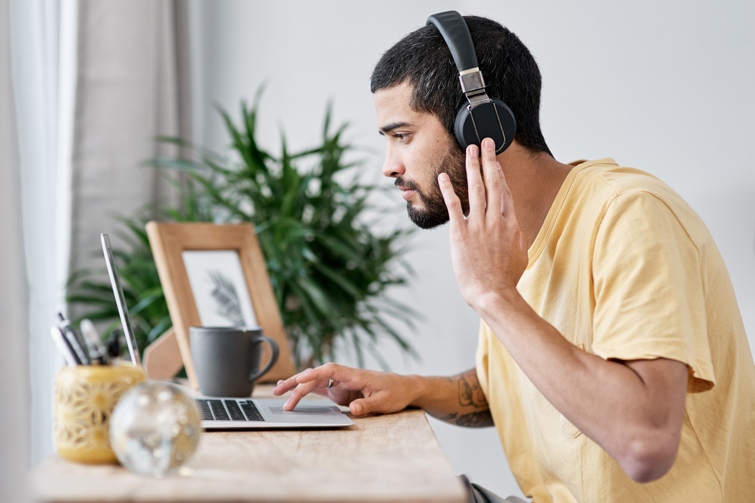 A remote worker using a noise-canceling headset while working.