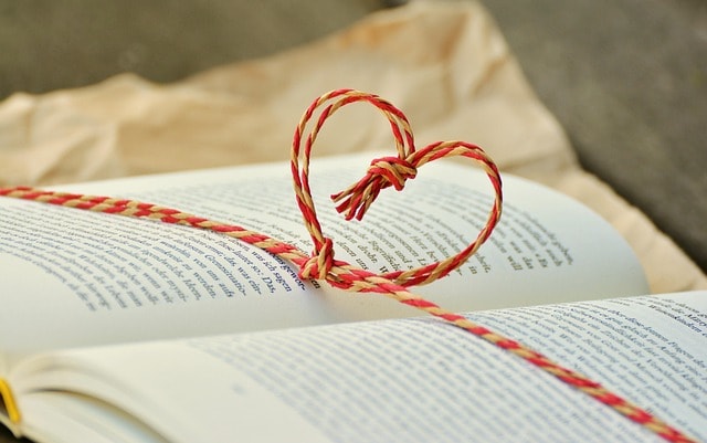 A book with a heart shaped string across the page, depicting the idea of a beloved, famous writer.