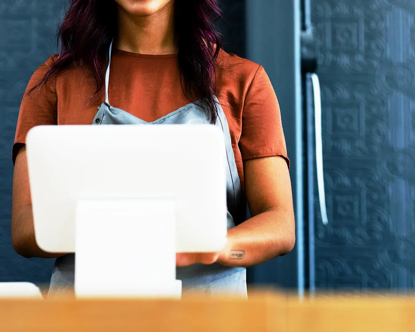 Restaurant worker using a laptop-based cloud POS system for business operations