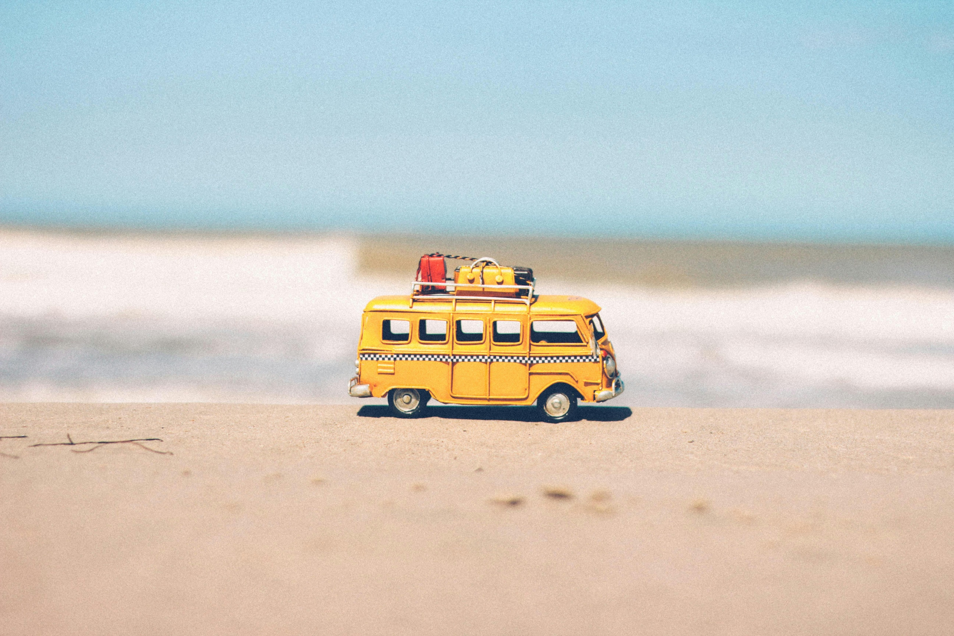 Photo de Nubia Navarro (nubikini): Close-up photograph of a miniature yellow van ready for camping, placed on the Hossegor sandy beach.