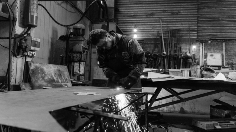 A welder working on fixing metal sheets for aircrafts. 