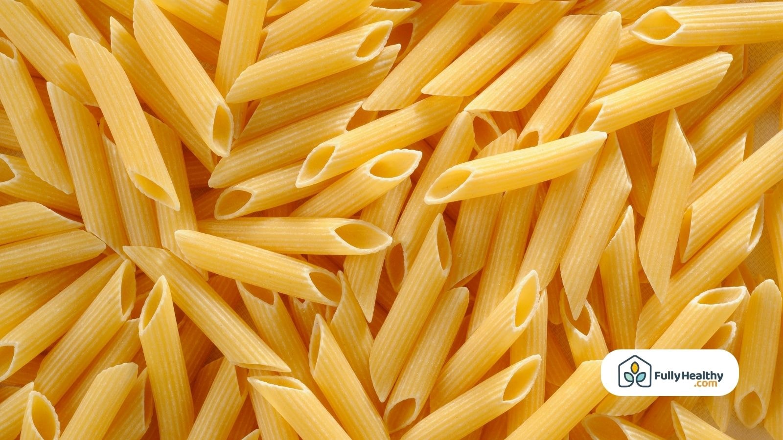 Close-up of uncooked penne pasta with a FullyHealthy logo