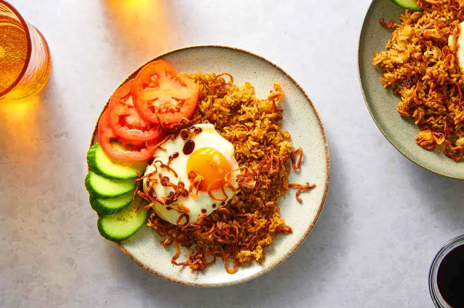 Indonesian nasi goreng with fried egg, crispy fried shallots, tomatoes and cucumber