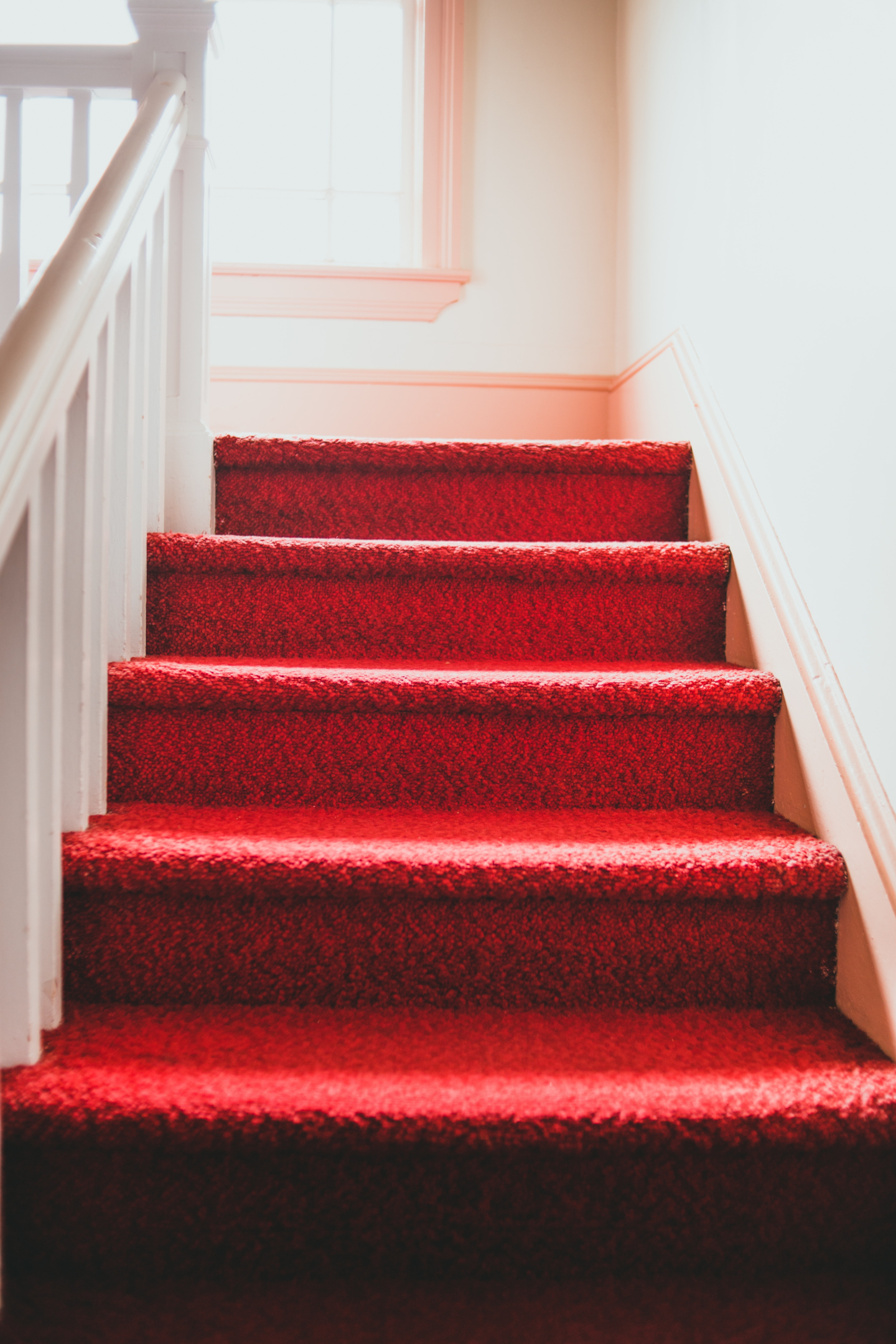 A person installing carpeted stairs on a staircase