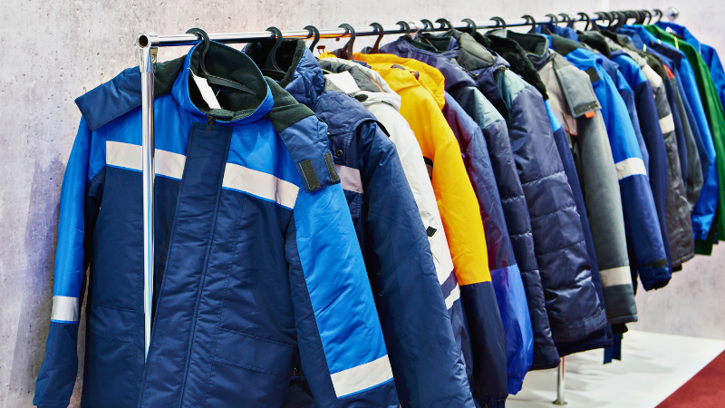 A rack of colorful work gorpcore jackets, some with reflective stripes.