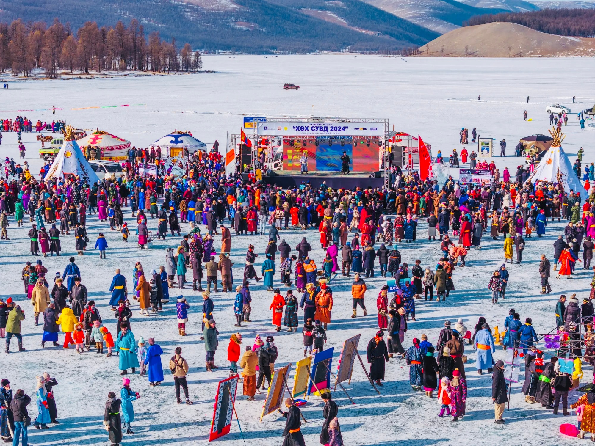 Nomadic people in colorful clothing celebrate on an icy field during Mongolia’s very cold winters.