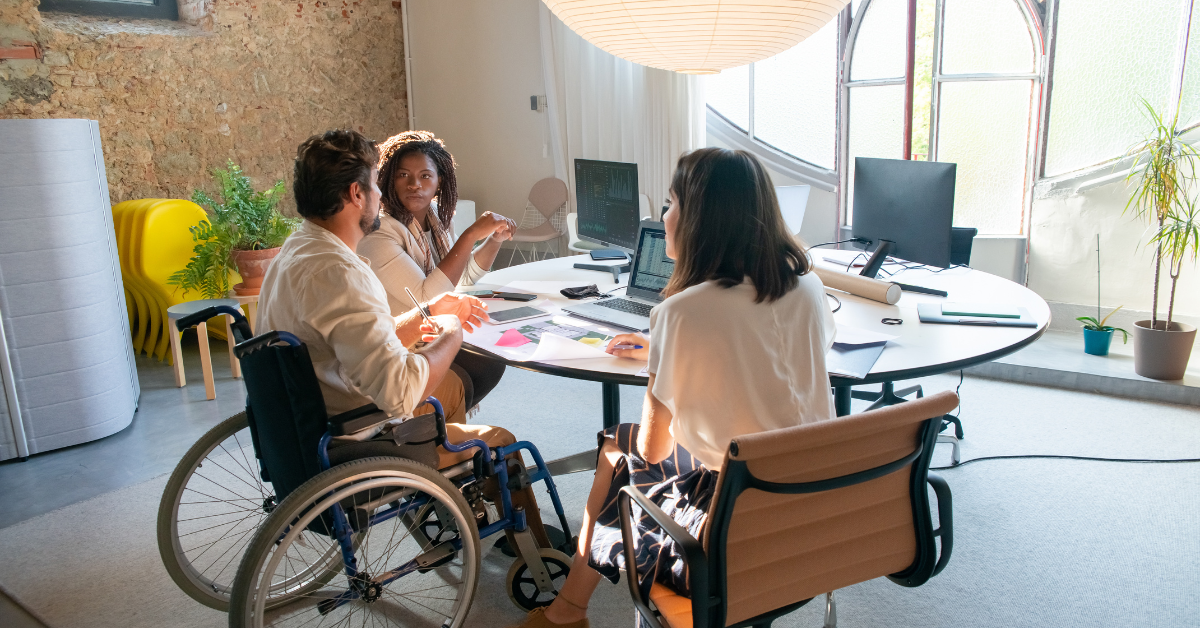 NDIS Housing - 3 person with one of them is disable are discussing on a topic seeing on digital displays and laptops