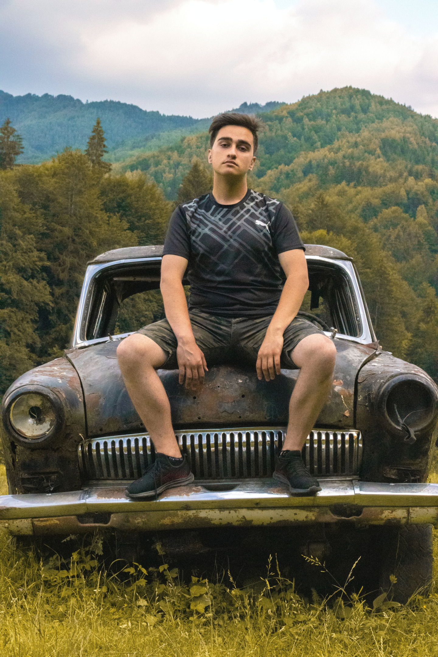 Man sitting on junk car