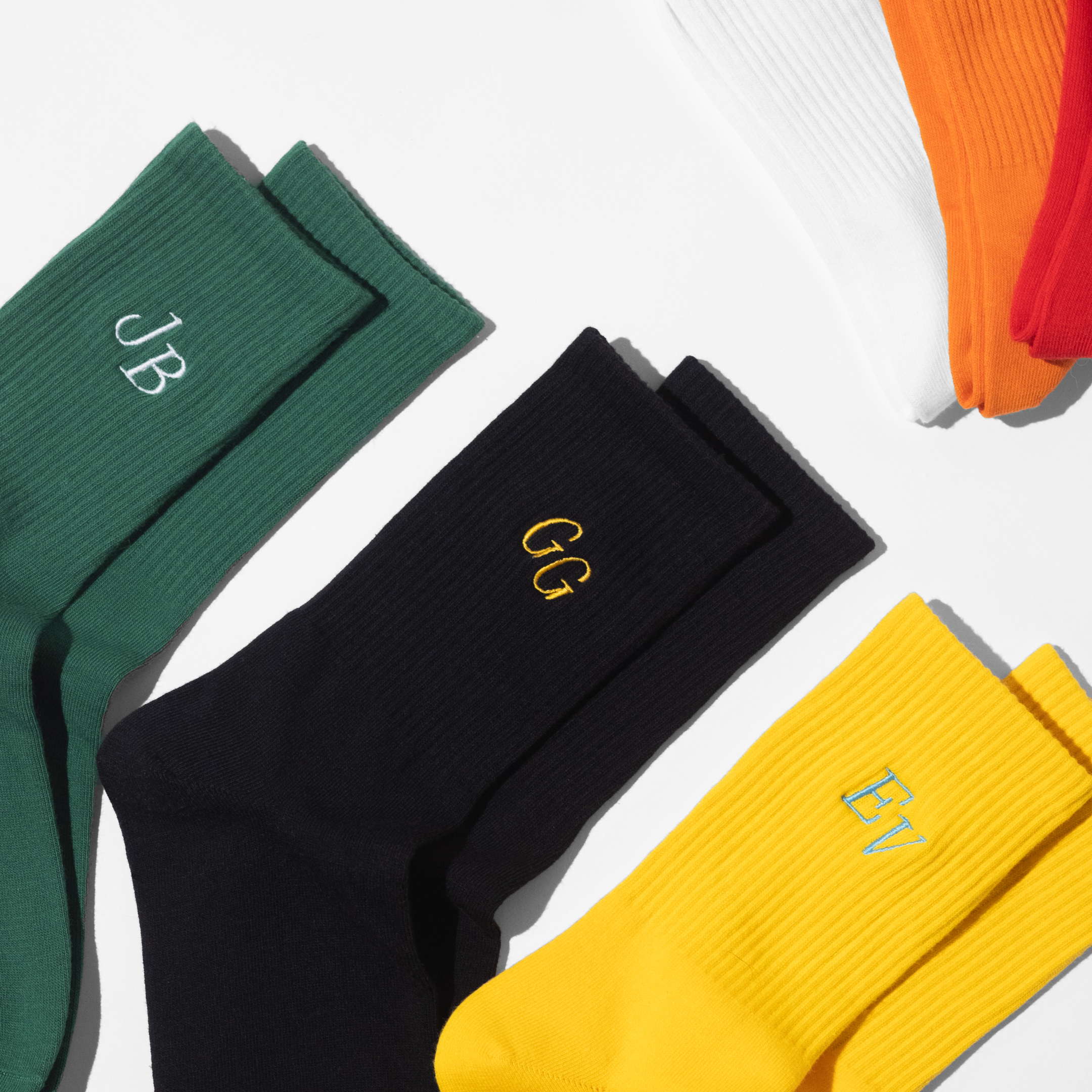 A collection of mens customised crew socks with initials embroidery on each sock of the pair.
